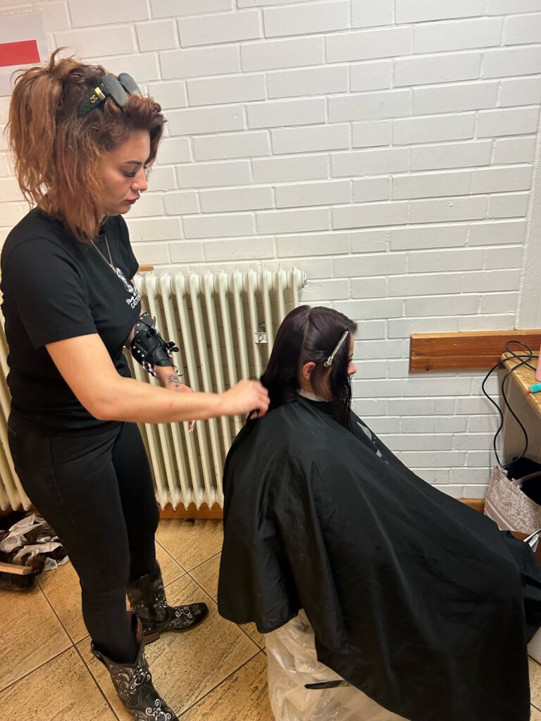 Friseurin Jessica schneidet einem Mädchen die Haare. Sie hatte die Idee zum Besuch der Barber Angels. Foto: Petry