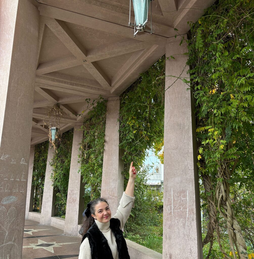 Anna Kosar deutet auf eine Laterne an den Kolonnaden am Pirmasenser Exerzierplatz