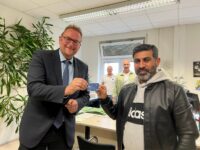 Der Pirmasenser Oberbürgermeister überreicht dem Syrer Morad Muhsen die erste Bezahlkarte. Foto: Thomas Müller