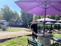 Biergarten-Betreiber Andreas Schütz an einem der Fässer mit Schirm. Foto: Müller