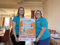 Anna Wölfling (links) und Claudia Engel-Heiser präsentieren das Plakat zum Kinderspieltag. Foto: Müller