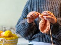 Woman knitting on the bed